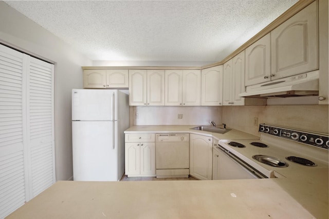 kitchen with sink, white appliances, a textured ceiling, and cream cabinets