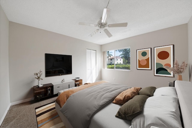 bedroom with ceiling fan, a textured ceiling, and carpet flooring