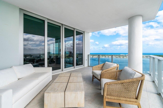 balcony with an outdoor living space and a water view