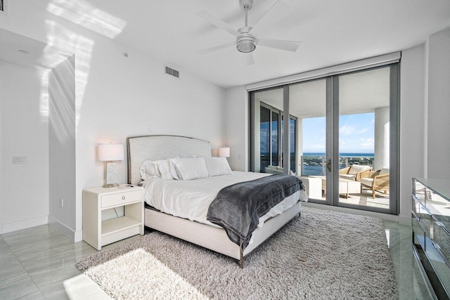 bedroom with floor to ceiling windows, access to outside, ceiling fan, and a water view