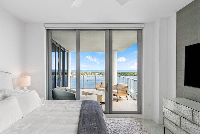 bedroom featuring access to exterior, ceiling fan, and expansive windows