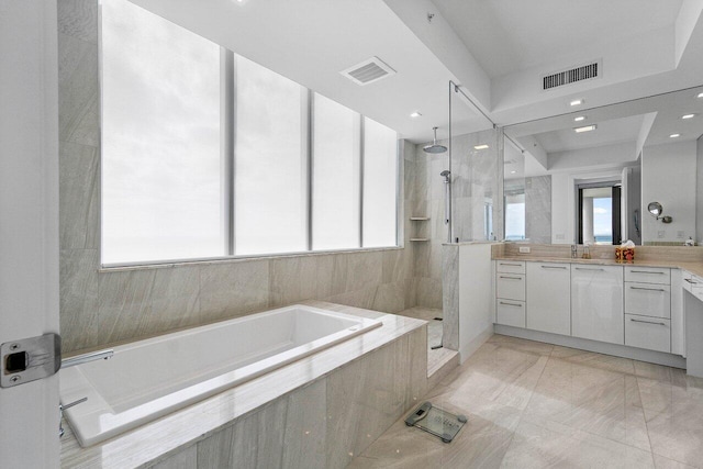 bathroom with separate shower and tub, a wealth of natural light, and vanity