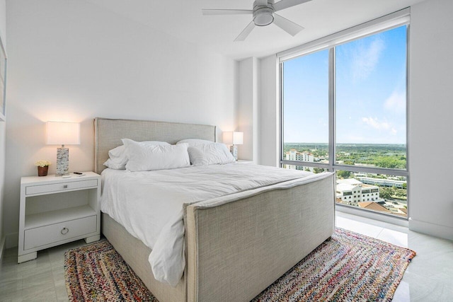 tiled bedroom featuring expansive windows and ceiling fan