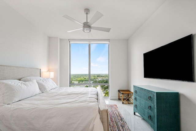 bedroom with ceiling fan, light hardwood / wood-style flooring, and expansive windows