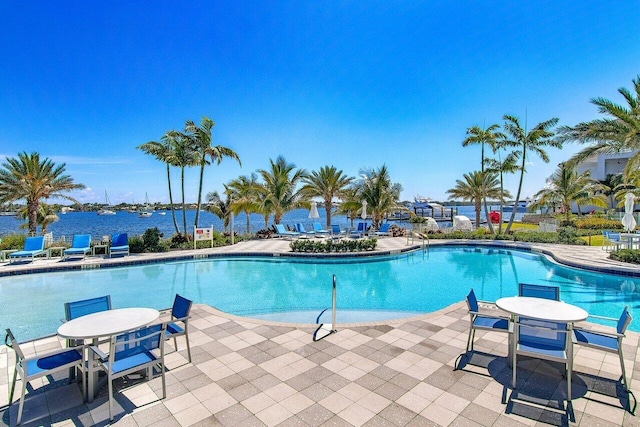 view of swimming pool with a patio area and a water view