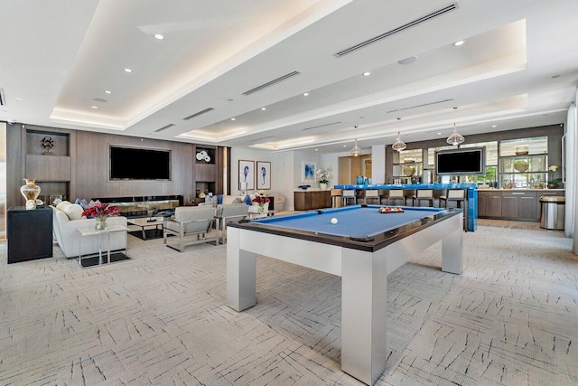 game room with a raised ceiling and billiards