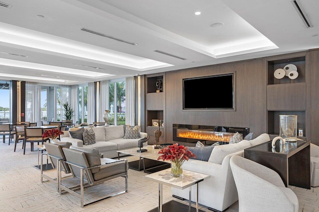 living room featuring a wall of windows and a tray ceiling