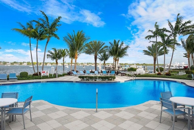 view of pool featuring a water view and a patio area