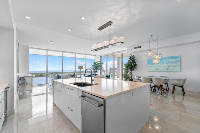 kitchen with pendant lighting, white cabinetry, and an island with sink