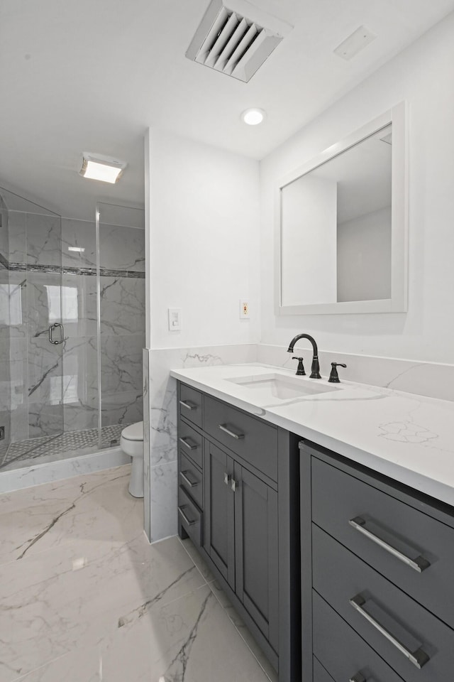 bathroom with vanity, toilet, and a shower with shower door