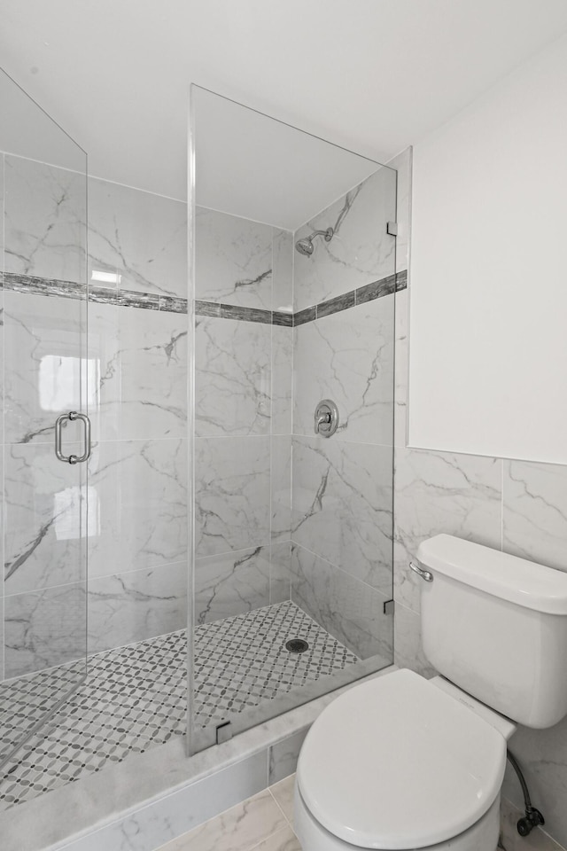 bathroom with toilet, an enclosed shower, and tile walls