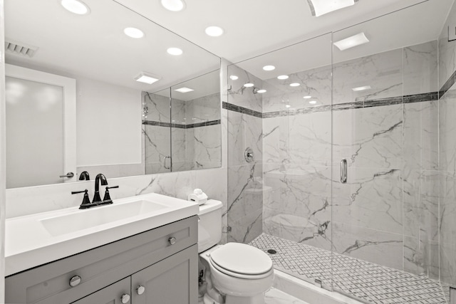 bathroom featuring vanity, toilet, tile walls, and a shower with shower door