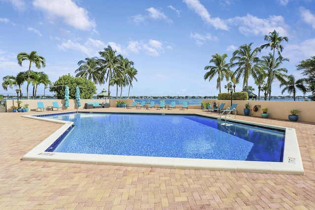 view of swimming pool with a patio and a water view