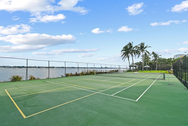 view of tennis court with a water view