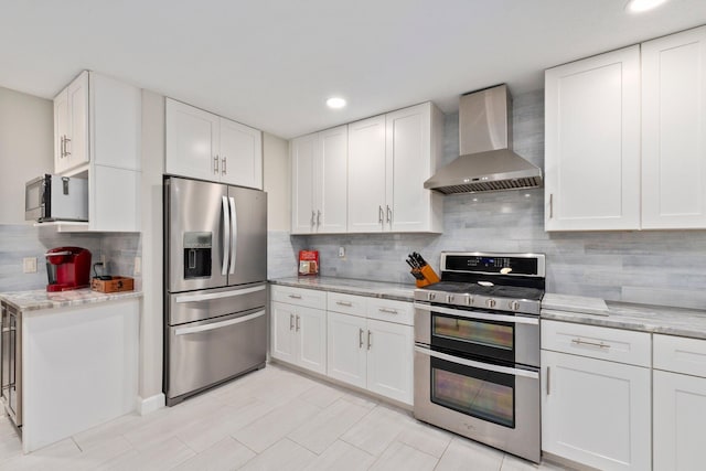 kitchen with white cabinets, wall chimney exhaust hood, and stainless steel appliances