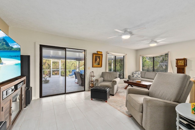 living room featuring ceiling fan and a textured ceiling