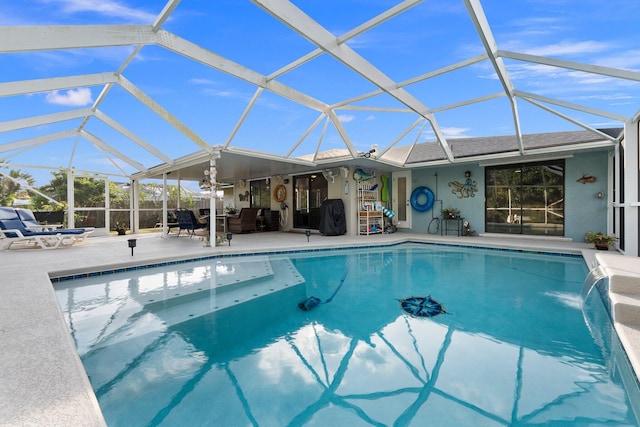 view of pool with glass enclosure, pool water feature, a patio area, and a jacuzzi