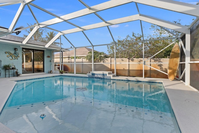 view of pool featuring glass enclosure and a patio