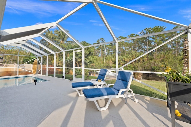 view of pool with glass enclosure and a patio area