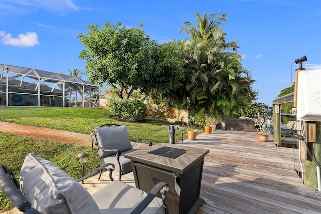 wooden deck featuring a lawn and a lanai