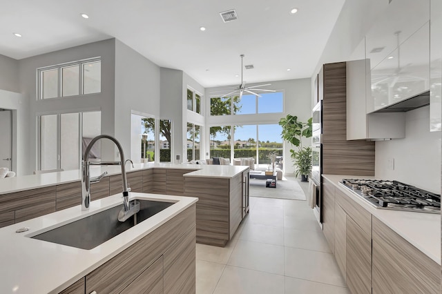 kitchen with white cabinets, sink, ceiling fan, appliances with stainless steel finishes, and light tile patterned flooring