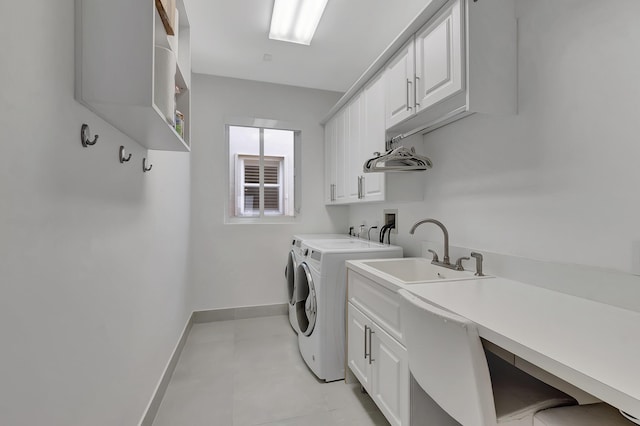 laundry room featuring light tile patterned flooring, cabinets, independent washer and dryer, and sink