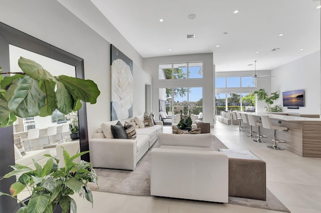 living room featuring ceiling fan and a high ceiling