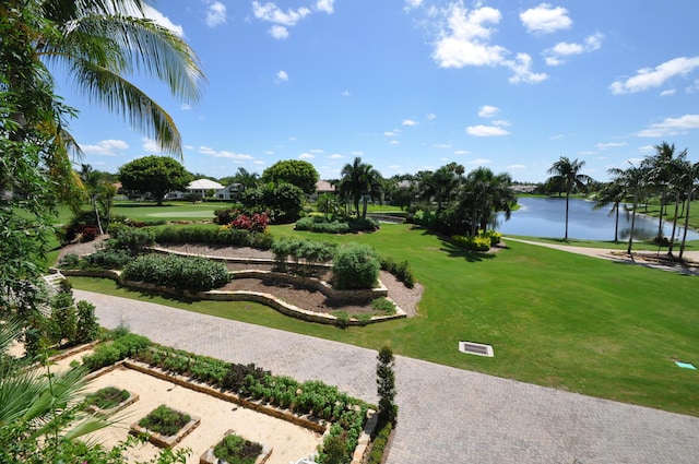 view of property's community with a lawn and a water view