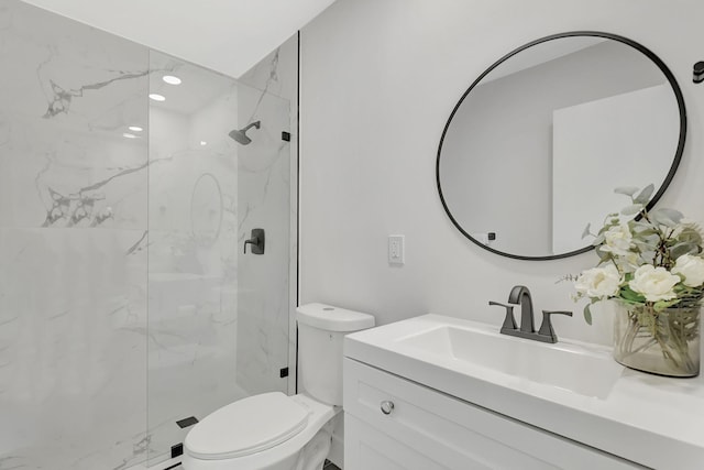 bathroom with vanity, toilet, and tiled shower