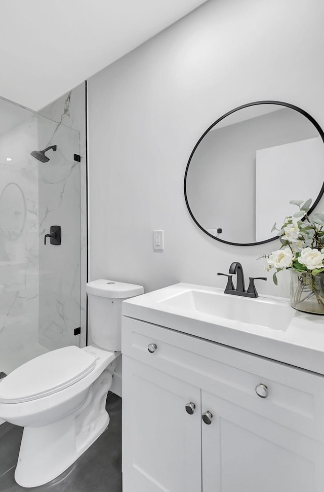 bathroom with vanity, toilet, and tiled shower