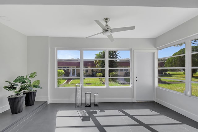 unfurnished sunroom featuring ceiling fan