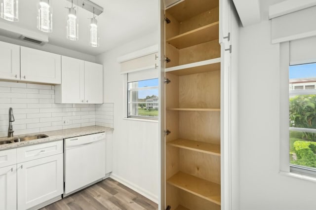 kitchen featuring backsplash, dishwasher, white cabinetry, and sink