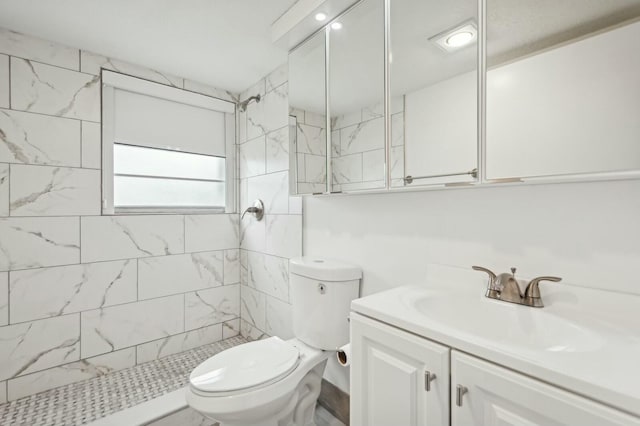 bathroom featuring vanity, toilet, and a tile shower