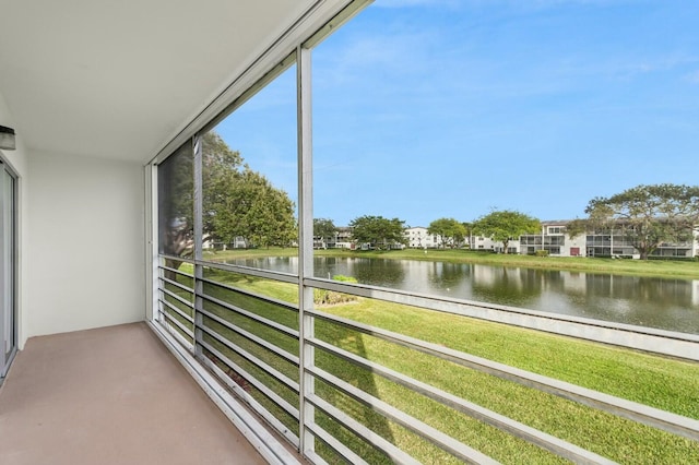 sunroom featuring a water view