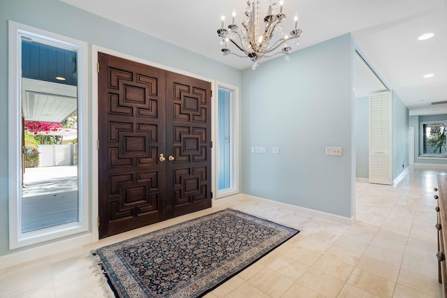 tiled entrance foyer with a notable chandelier