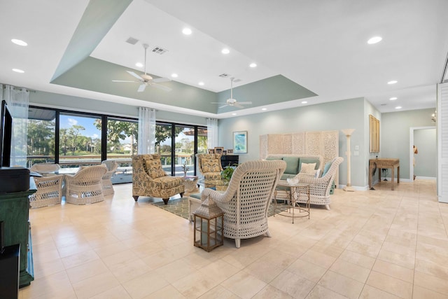 tiled living room featuring a raised ceiling, ceiling fan, and a towering ceiling