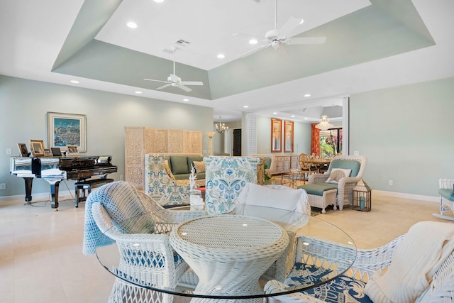 tiled dining space featuring ceiling fan with notable chandelier, a towering ceiling, and a raised ceiling