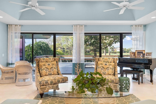 living room featuring ceiling fan and a tray ceiling