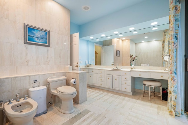 bathroom featuring vanity, a bidet, tile patterned flooring, toilet, and tile walls