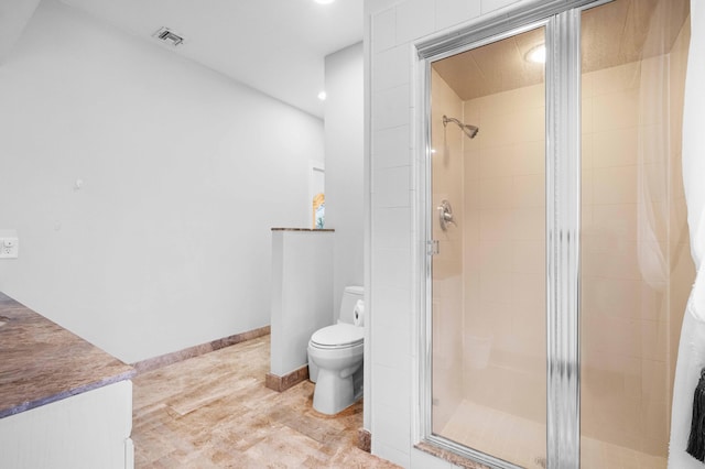 bathroom with toilet and a shower with door