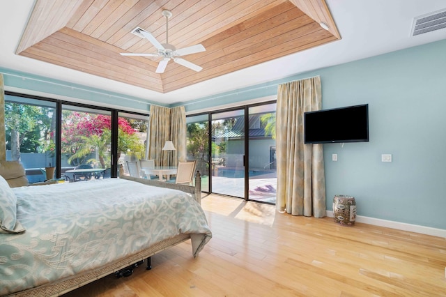 bedroom featuring access to outside, ceiling fan, a tray ceiling, and wood ceiling