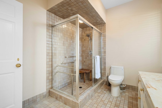 bathroom featuring tile patterned flooring, vanity, toilet, and a shower with door