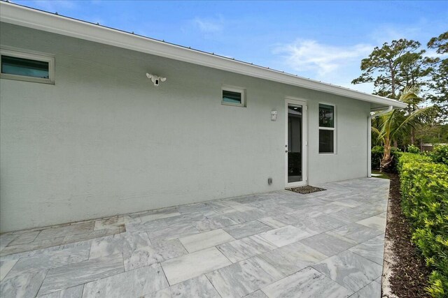 rear view of house with a patio area and stucco siding