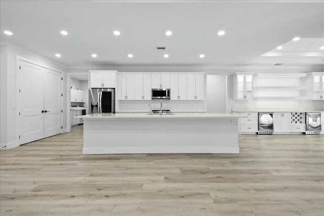 kitchen with wine cooler, open shelves, appliances with stainless steel finishes, white cabinetry, and a large island with sink