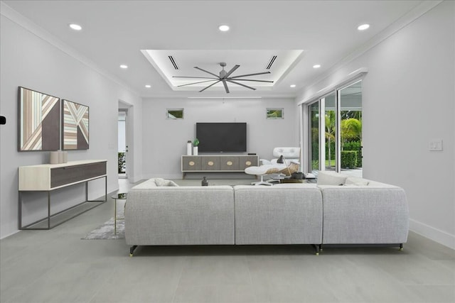 living room featuring ornamental molding, a tray ceiling, baseboards, and recessed lighting