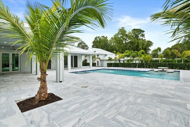 view of swimming pool featuring french doors, a patio area, and a fenced in pool