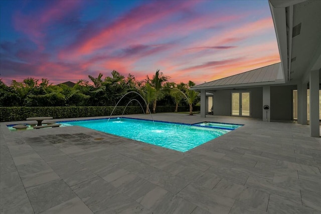 pool at dusk featuring a fenced in pool, french doors, and a patio