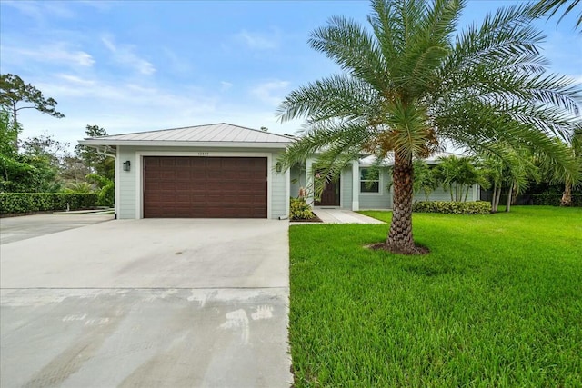 view of front of home with concrete driveway, metal roof, an attached garage, a standing seam roof, and a front lawn