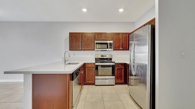 kitchen with kitchen peninsula, appliances with stainless steel finishes, light tile patterned floors, and sink