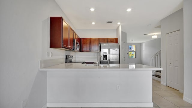 kitchen with sink, stainless steel appliances, light tile patterned flooring, and kitchen peninsula